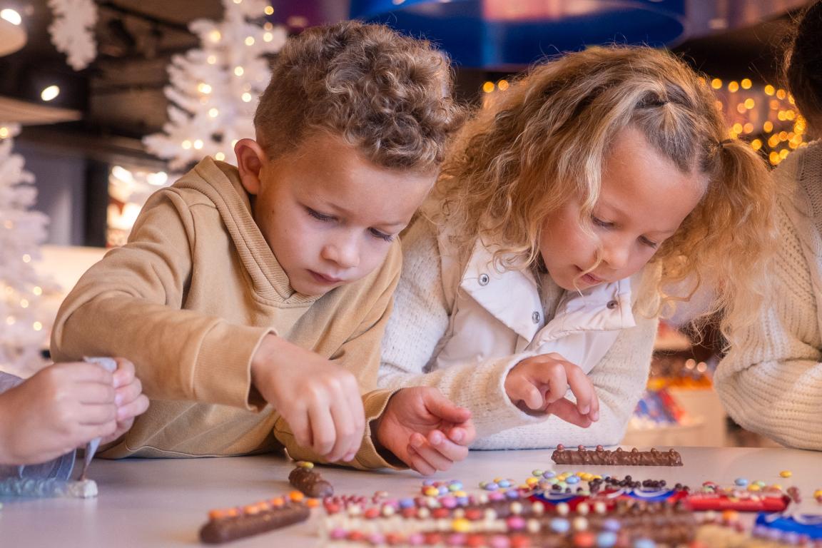 Schoggi-Atelier im Chocolarium. Kinder verzieren Prügeli