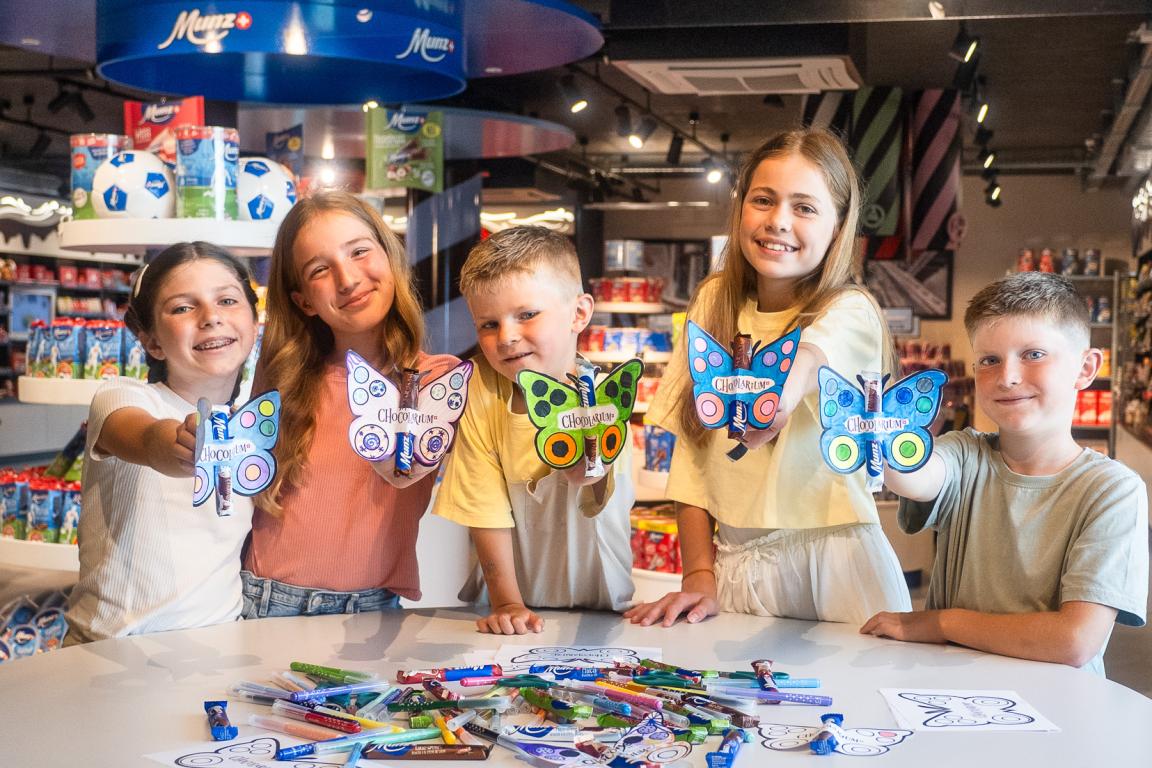 Kinder, die einen Munz Schmetterling mit Schokolade gebastelt haben