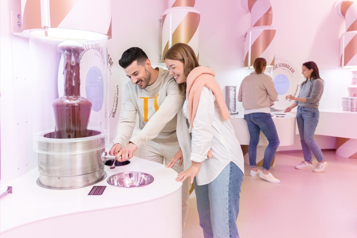 Chocolarium Tour. 2 Menschen geniessen Schokolade im Glücksraum