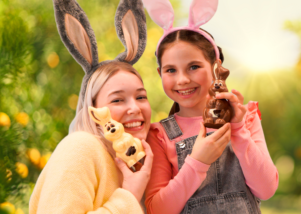 Eine Frau und ein Mädchen mit je einem Osterhasen aus Schokolade